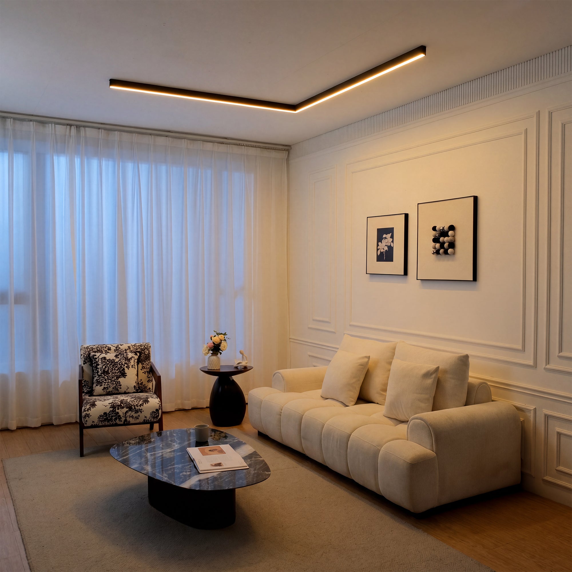 A single black ceiling lamp placed above a cozy living room corner, giving the space gentle warm light while keeping the ceiling design clean and understated.