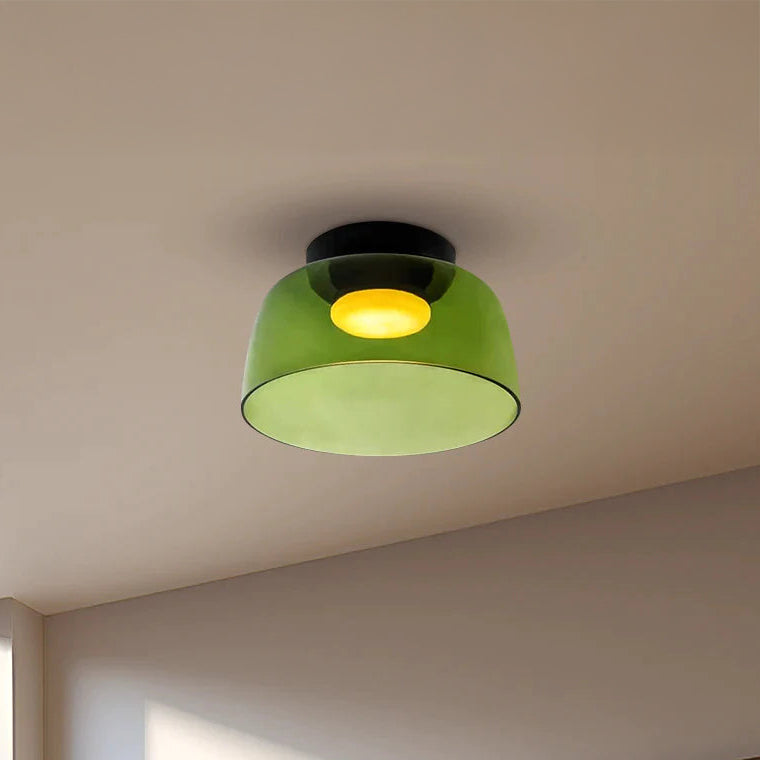 Green acrylic flush mount ceiling light with a rounded single drum shade and soft 2700K glow in a neutral room.