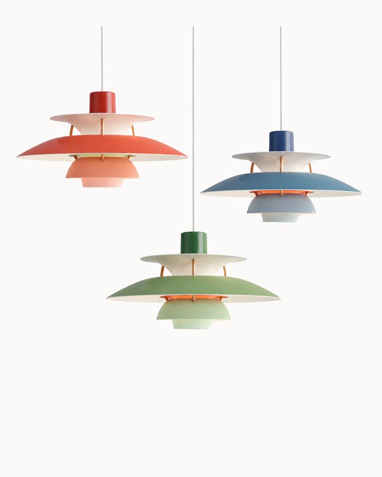 Colorful pendant lights with layered shades in red, blue, and green finishes, showcasing a modern Scandinavian-inspired design.