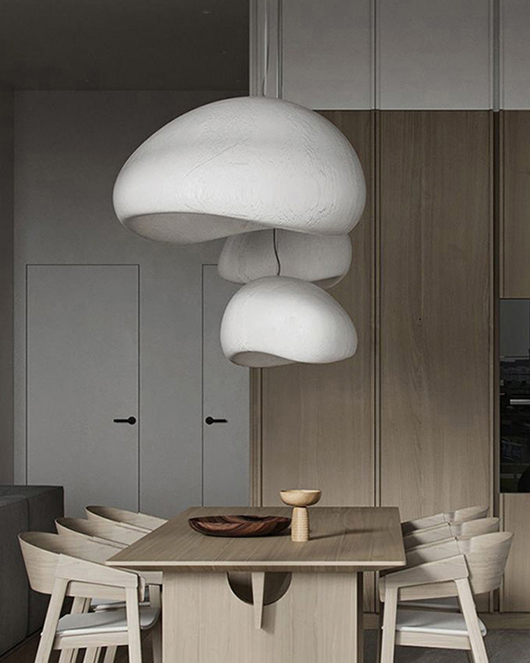 Cascading white resin pendants float above a grey dining nook, combining soft curves with warm light.
