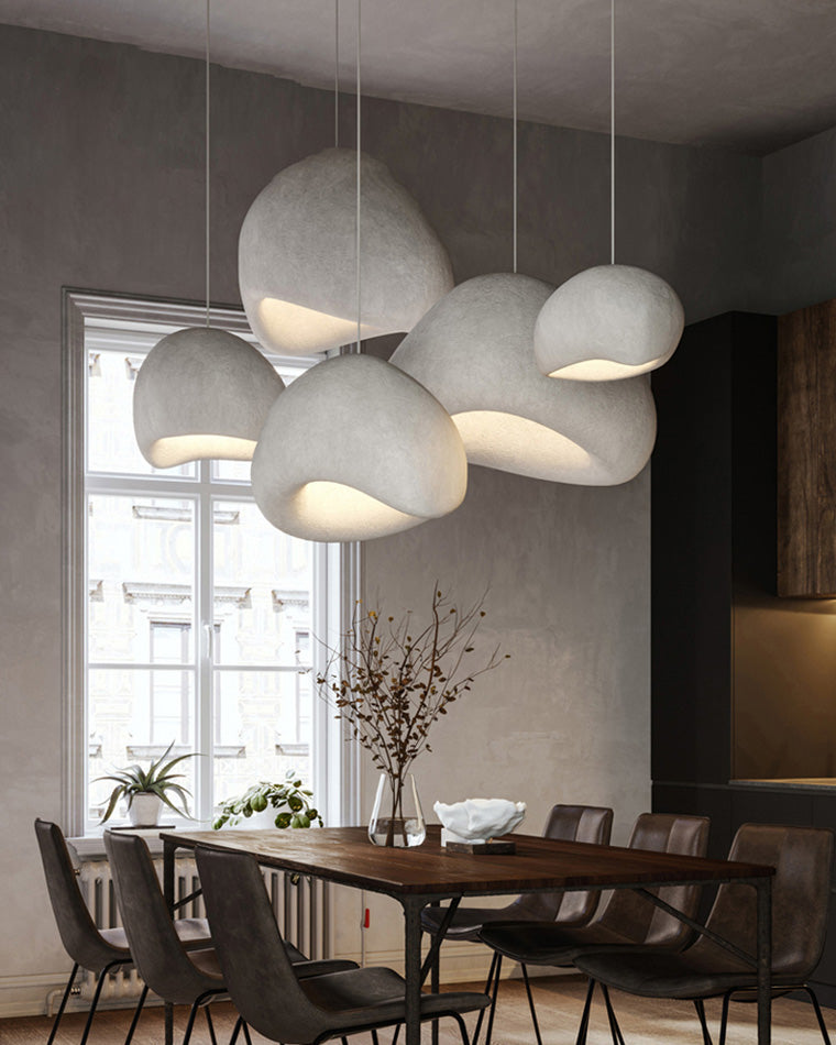 Three white resin pendants brighten a window-side dining room with soft, downward light.