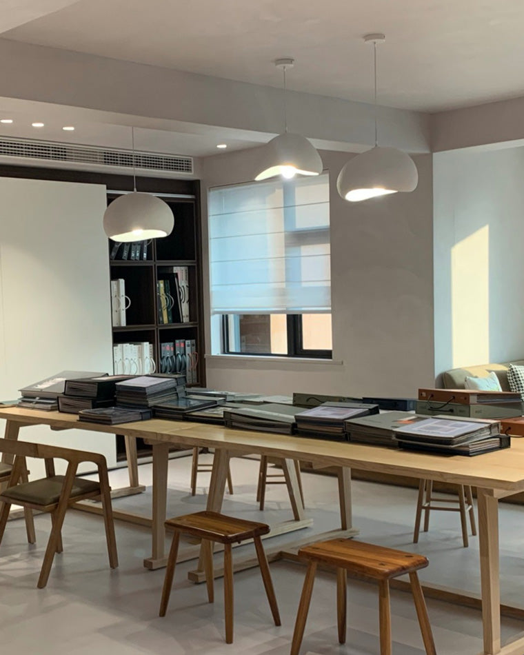 Multiple pendant lights span an open kitchen counter and adjoining dining area without interrupting sightlines.