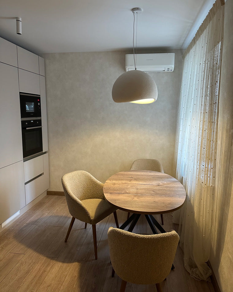 A grey dome dining room chandelier centers warm light over a compact round dining nook.