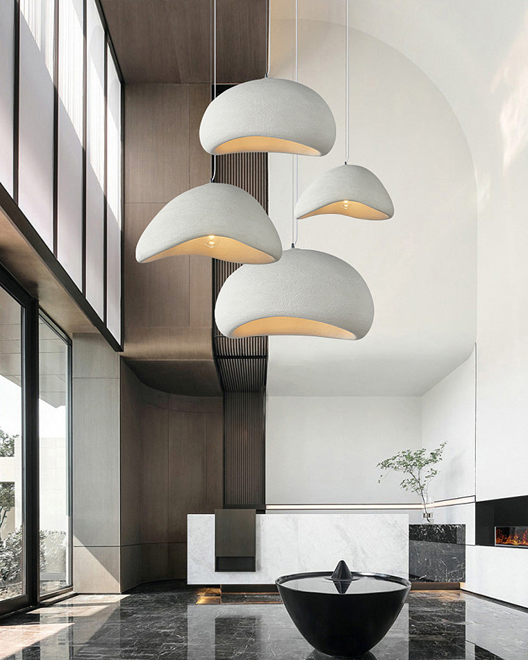 Four organic white pendant lights bring warm task light and sculptural rhythm to a bright kitchen island.