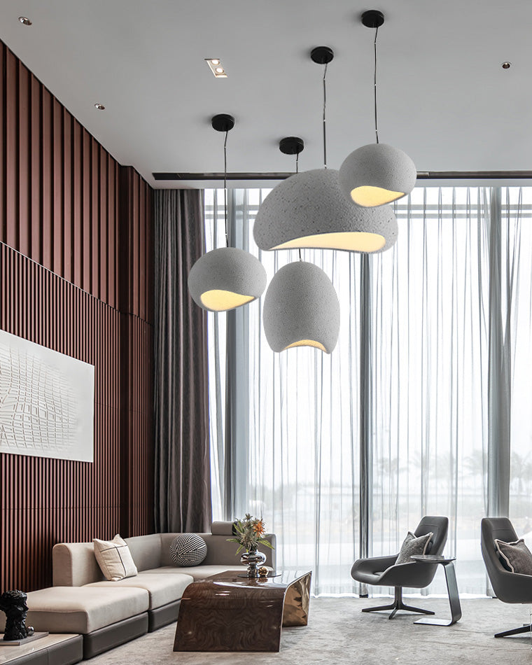 A multi-light pendant lighting installation fills the vertical space of a high-ceiling modern living room.