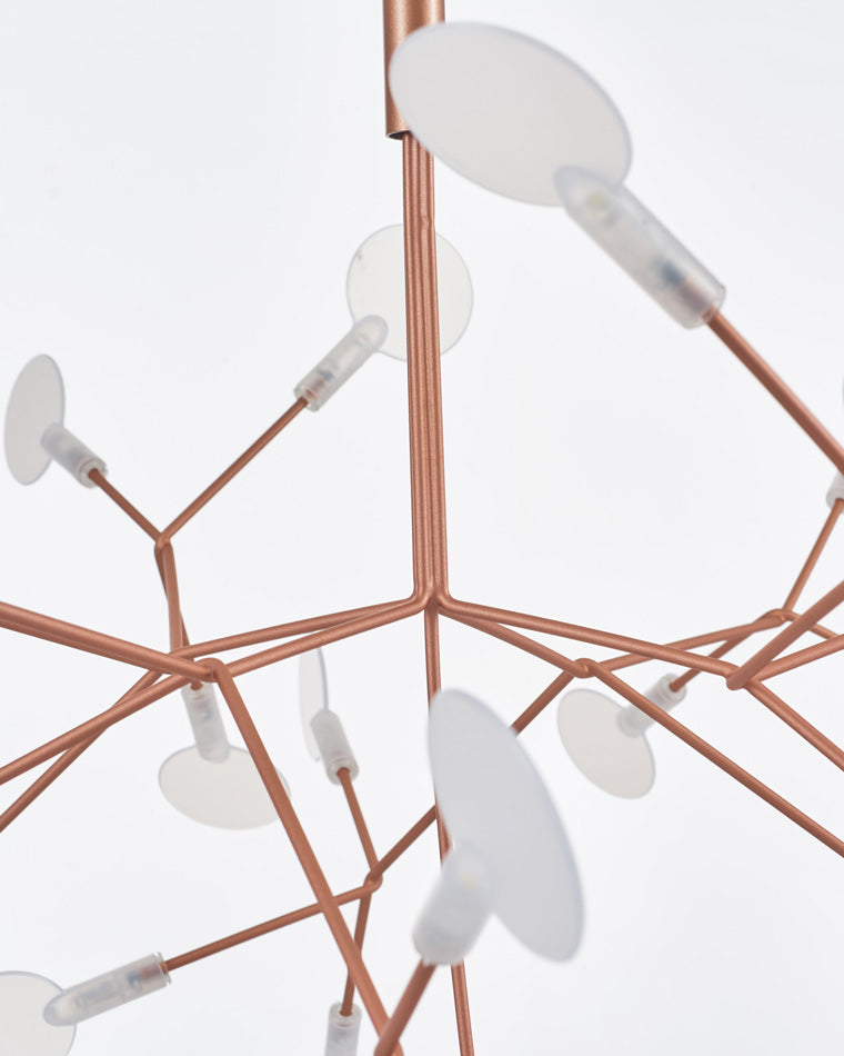 Close-up of translucent acrylic leaves and rose-gold joints, revealing how refined materials soften each firefly-like point of light.
