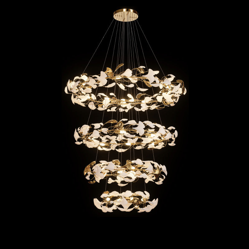 Four-tier circular ginkgo chandelier arranged in widening rings of glowing white and gold leaf forms.