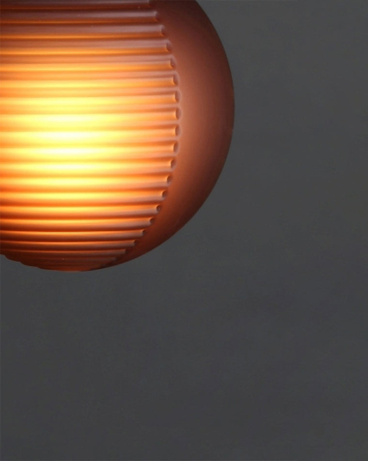 Macro view of a ribbed purple glass globe glowing warmly from within.
