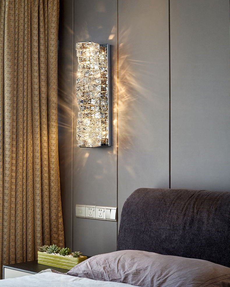 Pair of tall crystal wall sconces flanking a wall-mounted mirror above a mantel