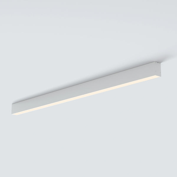 A modern linear LED ceiling light fixture in a sleek rectangular white housing, shown mounted on a plain light gray ceiling.