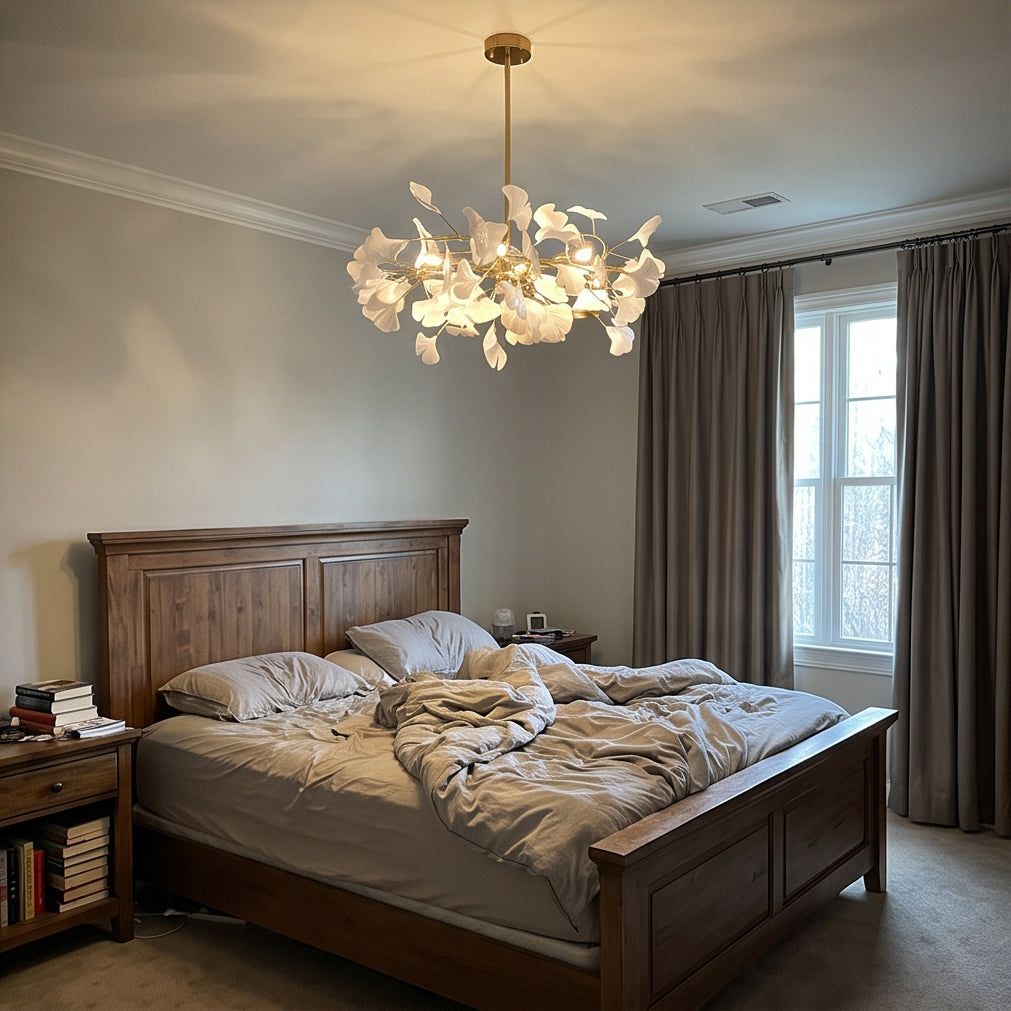 Elegant ginkgo chandelier for bedroom casting a soft glow above a dark wood bed