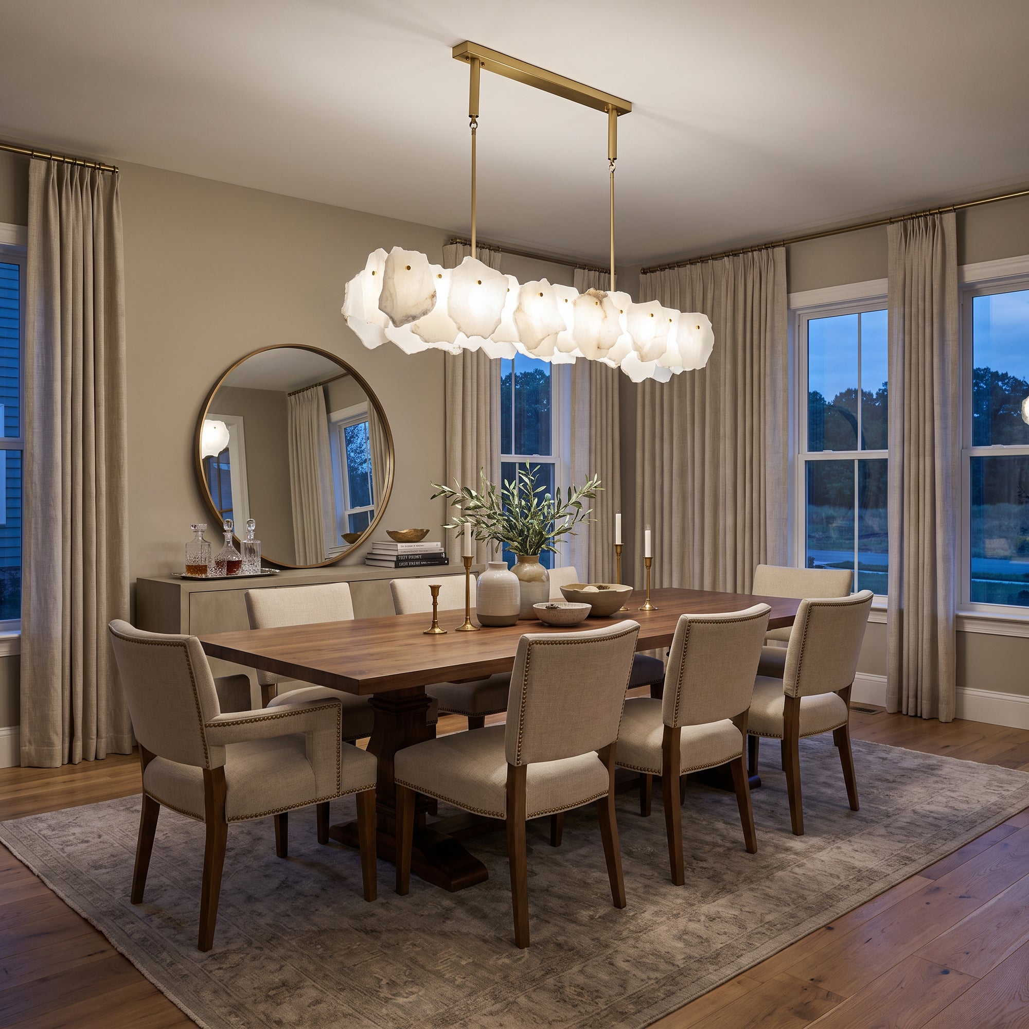 Modern linear alabaster chandelier installed above a dining table, featuring translucent stone shades and a rectangular gold frame in an elegant dining space
