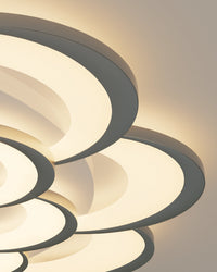 Close-up of the integrated LED petal rings on the WM1078 crystal LED ceiling light, showing layered curved light surfaces and dark-edged outlines.