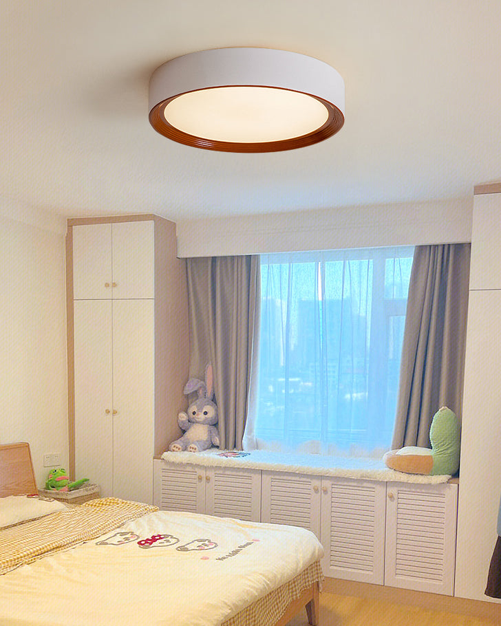Walnut flush ceiling lights bringing soft ambient light to a bright bedroom with window seating