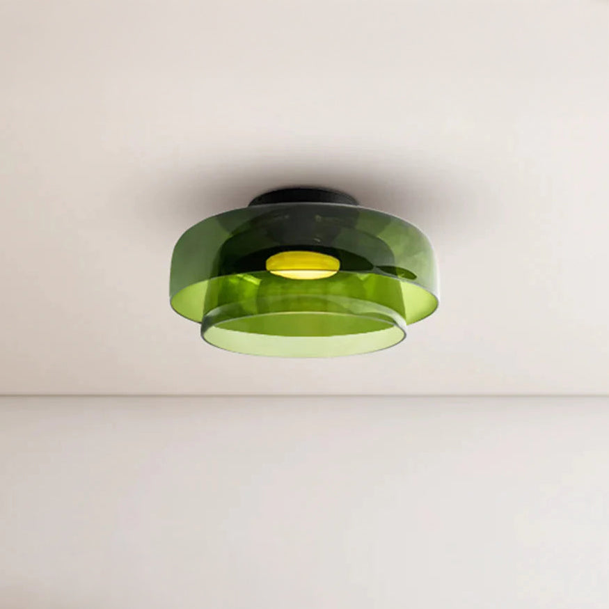 Green acrylic flush mount drum light fixture with two overlapping round shades and a warm light at the center.