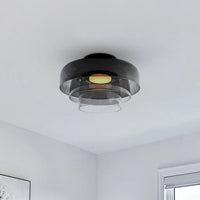 Three translucent smoked shades create unique flush mount lighting with a warm center glow in a soft gray room.