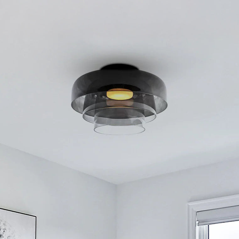 Three translucent smoked shades create unique flush mount lighting with a warm center glow in a soft gray room.