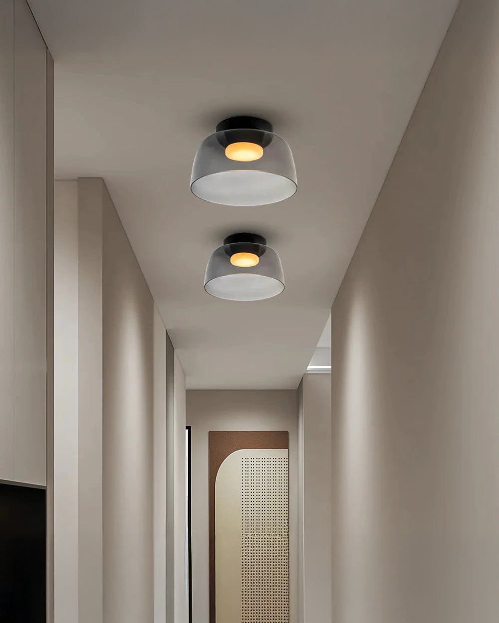 Two smoked acrylic hallway ceiling lights with compact drum shades and warm circular glows along a narrow modern corridor.
