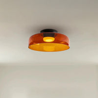 Wide amber circular ceiling lamp with a translucent acrylic shade and warm light on a clean white ceiling.