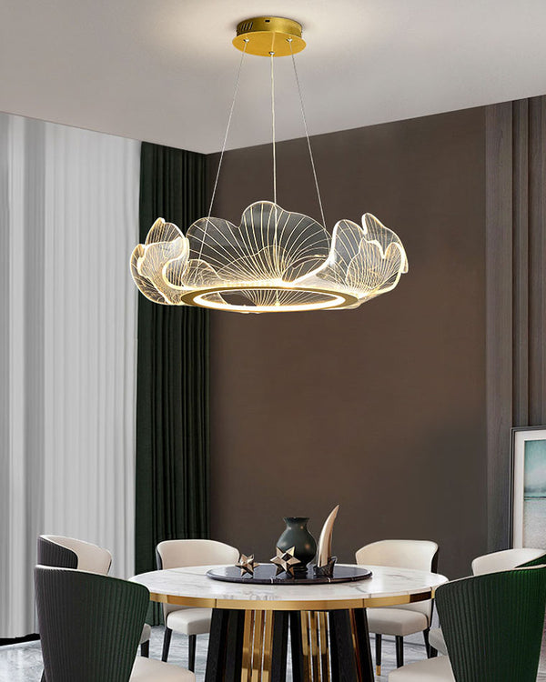 Round ginkgo leaf chandelier glowing above a modern dining table