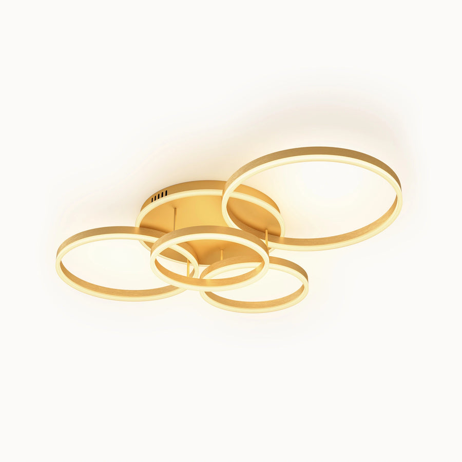 Gold multi-ring flush mount ceiling light with five staggered LED rings and a low-profile metal frame, shown illuminated against a white background.