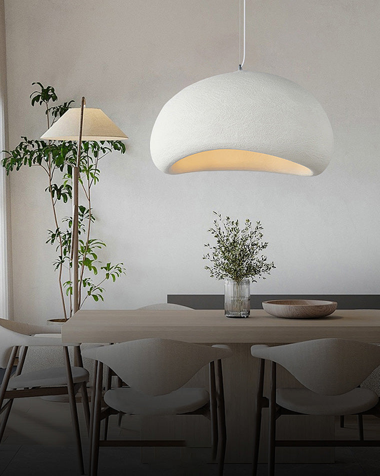 A broad white dining room chandelier centers the composition above a compact table and upholstered chairs.
