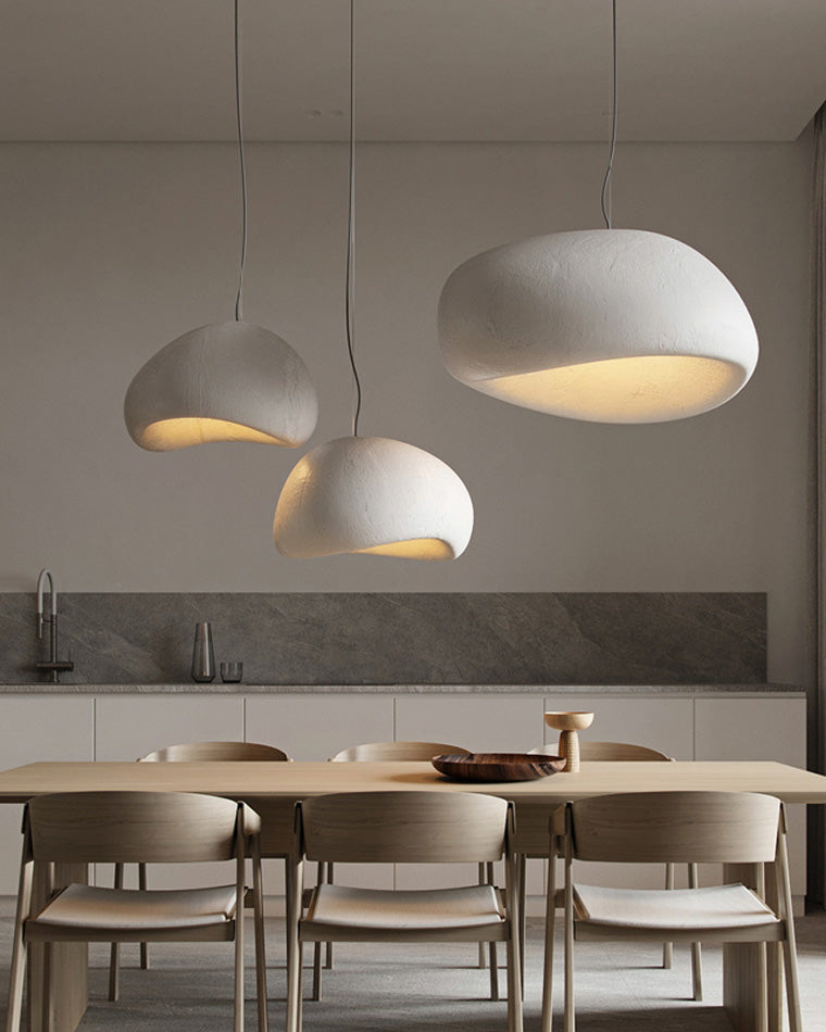 Three rounded resin shades form balanced pendant lighting above a pale wood dining table.