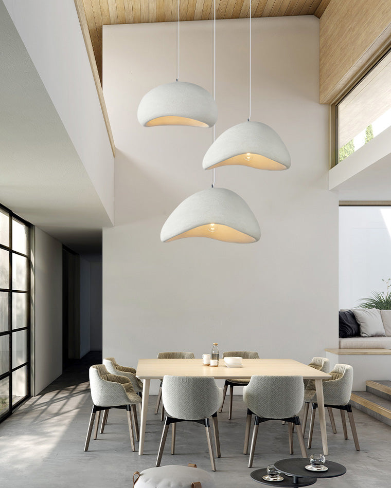 A cascading dining room chandelier descends through a double-height space, placing each resin shade at a different level.