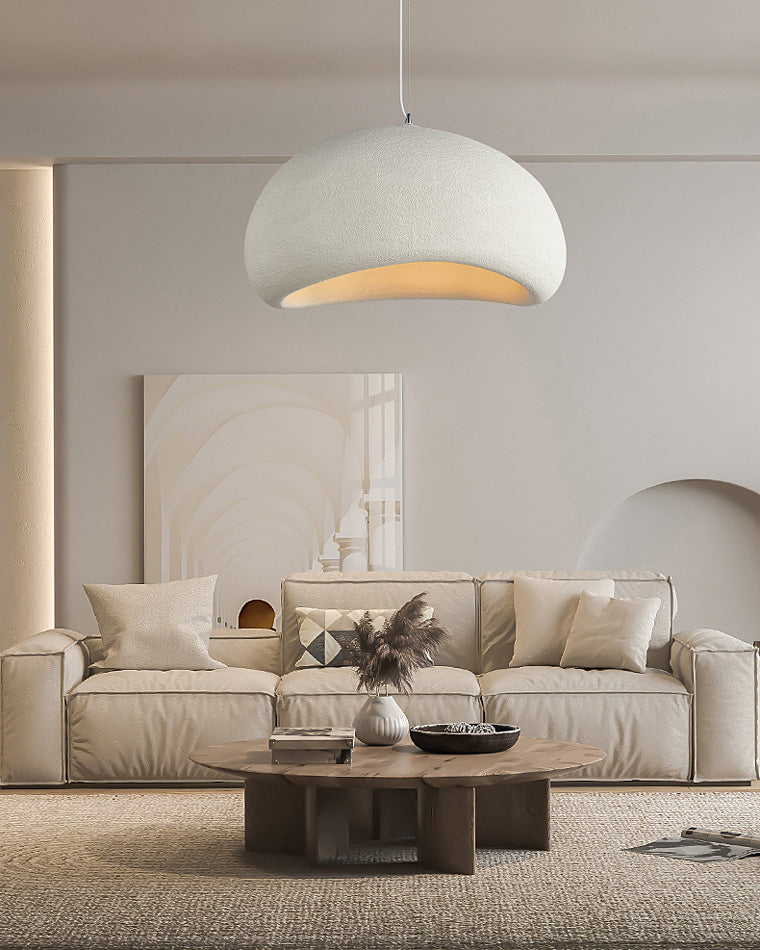 A wide white resin pendant becomes a restrained sculptural focal point above a neutral-toned living room.