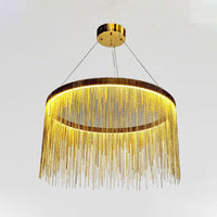 Low-angle close view of the gold 20-inch fringe chandelier, emphasizing the illuminated ring and richly layered metal-chain curtain.