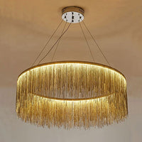 Close view of the gold 31-inch waterfall chandelier, with a wider illuminated ring sending warm reflections through its cascading chains.
