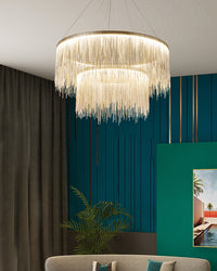 Gold chandelier glowing against a teal wall, where layered chain fringe builds depth and gives the room the decadent charm of a reimagined vintage chandelier.