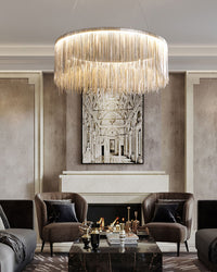 Silver chandelier centered above an elegant seating area, where flowing chain strands turn practical living-room lighting into restrained quiet luxury.