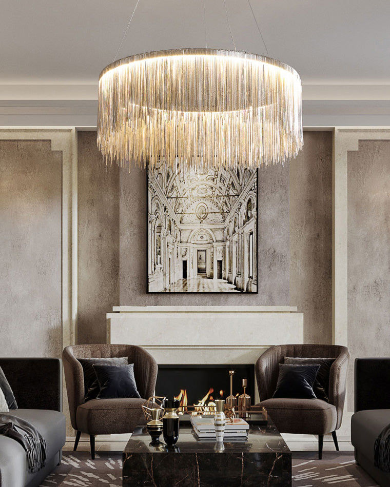 Silver chandelier centered above an elegant seating area, where flowing chain strands turn practical living-room lighting into restrained quiet luxury.