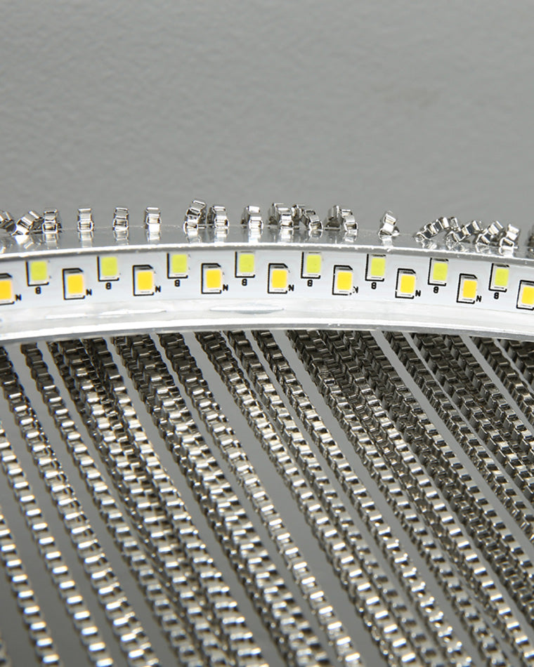 Close-up of the integrated circular light source and silver chain attachments, showing how the slim ring directs illumination through every strand.