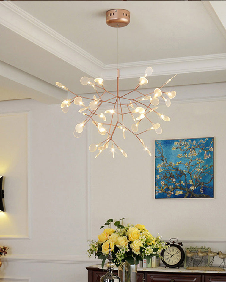 Rose-gold Heracleum chandelier glowing in a refined living room, making the ceiling feel alive with fireflies rather than merely illuminated.