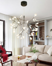 Black Heracleum living room chandelier spreading firefly-like light across a bright lounge while keeping the ceiling open and visually light.
