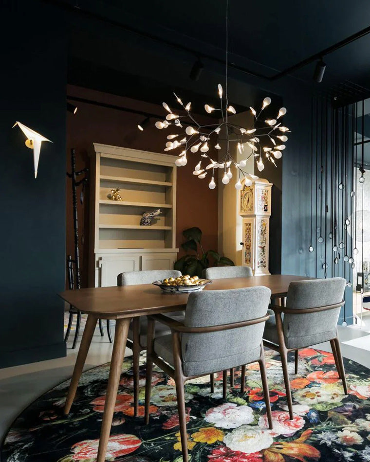 Black Firefly dining light fixture above a dark wood table, creating an intimate pool of light and a dramatic evening atmosphere.
