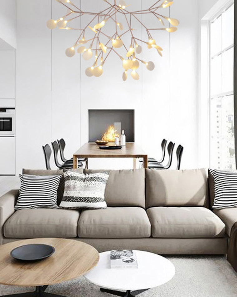 Rose-gold Heracleum organic chandelier floating above a neutral sofa, bringing firefly sparkle and sculptural depth to the calm interior.