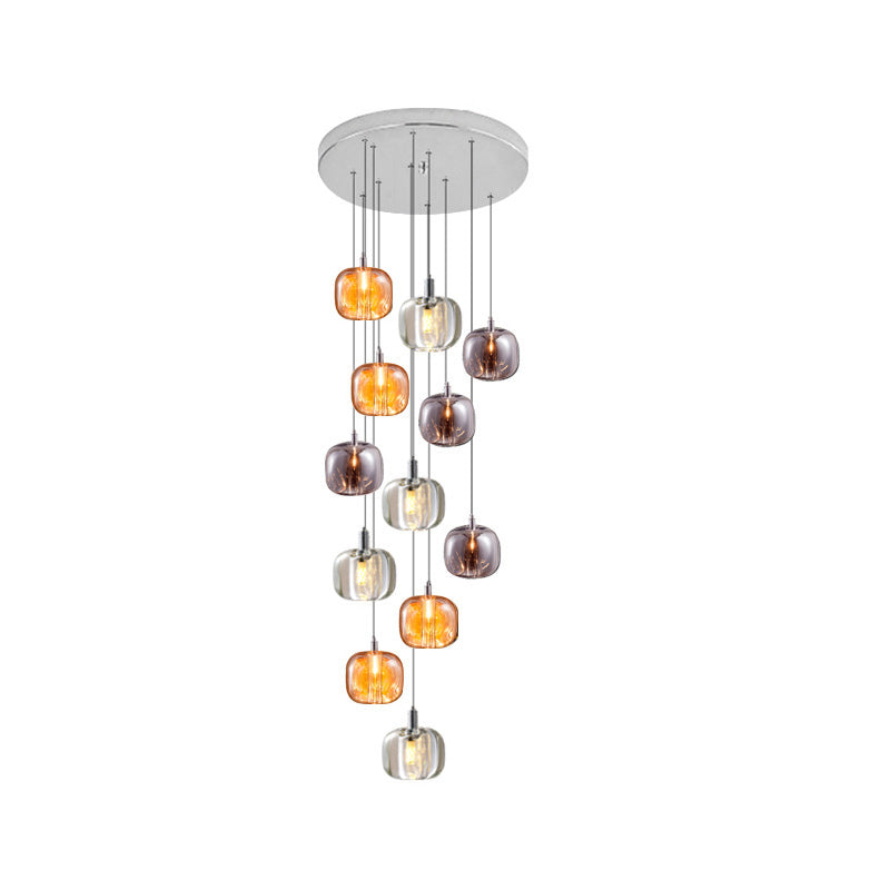 Twelve-light foyer chandelier with mixed amber, smoked, and clear glass pendants creating a fuller layered cascade.