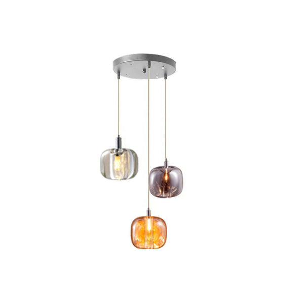 Three-light waterfall glass chandelier with one amber, one smoked, and one clear rounded shade on a compact round canopy.