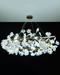 Gold-framed WM2414 chandelier glowing in cool white light on black.