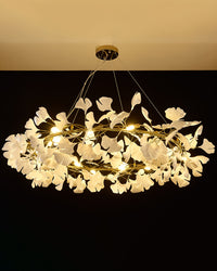 Gold-framed WM2414 chandelier glowing in warm white light on black.