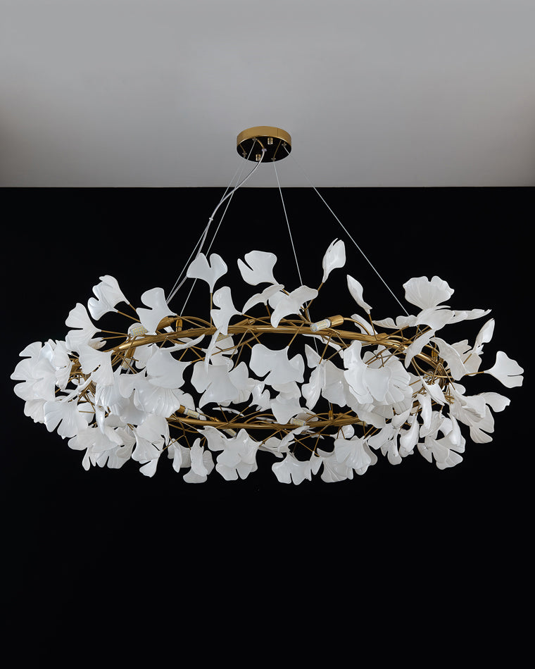 Unlit gold ceramic ginkgo leaf chandelier against a black background.