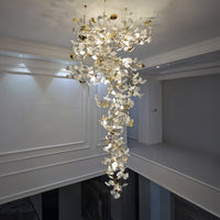 2 story foyer chandelier with white ceramic ginkgo leaves cascading through an open interior void.