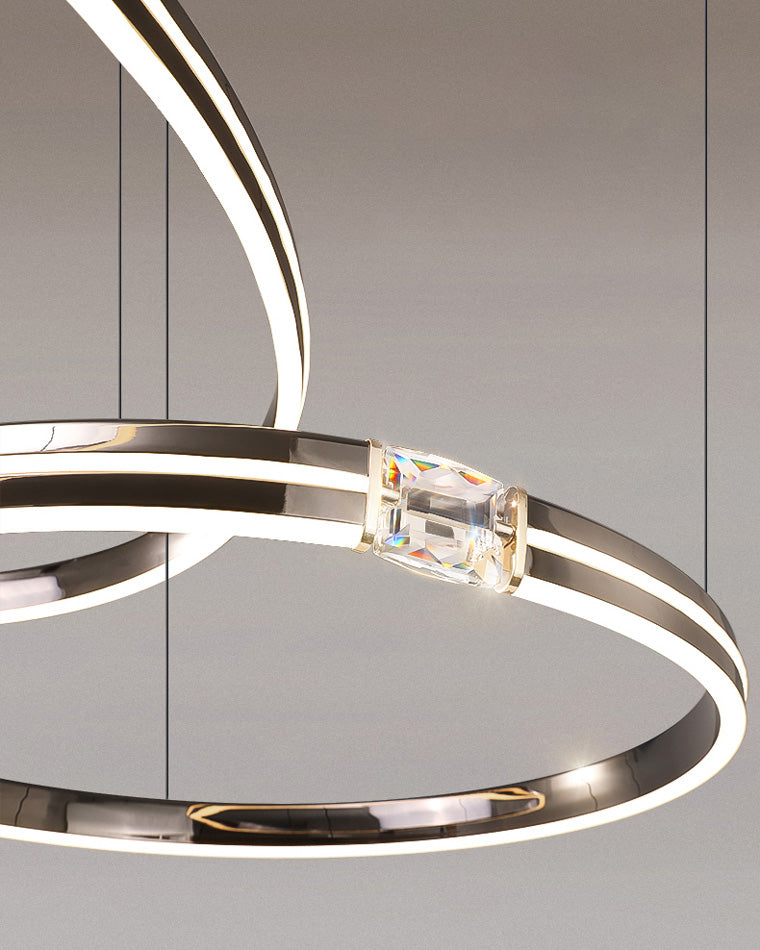 Overlapping illuminated rings create depth through staggered suspension, turning simple circles into a dynamic modern geometric chandelier.
