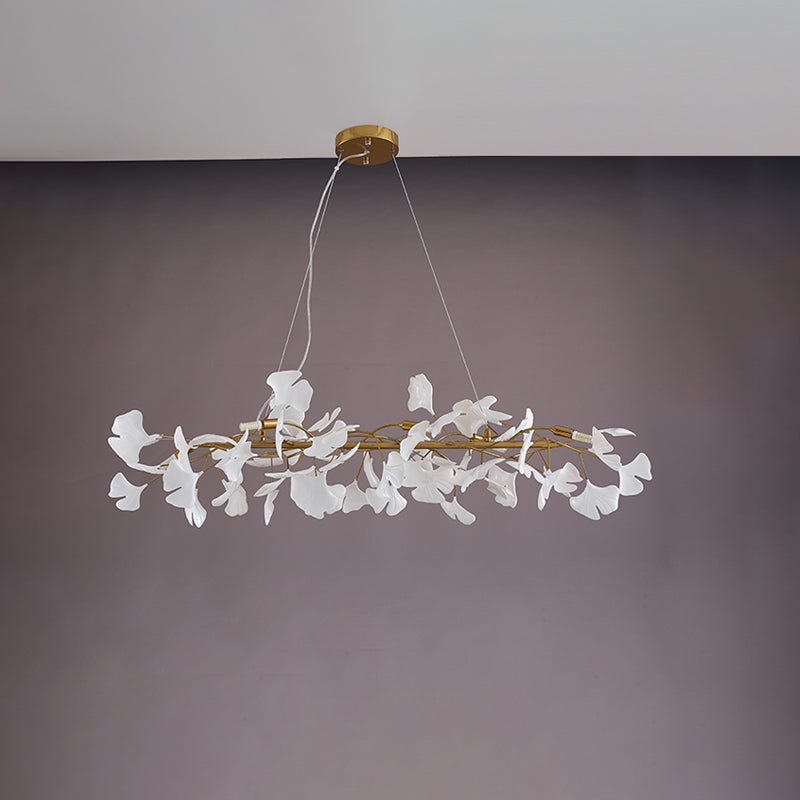 Gold 39-inch ginkgo leaf linear chandelier shown unlit with its ceramic leaves and branch frame.
