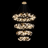 Four-tier circular ginkgo chandelier arranged in widening rings of glowing white and gold leaf forms.