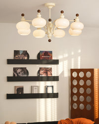 Beige eight-light glass chandelier above a lounge area with wall shelving