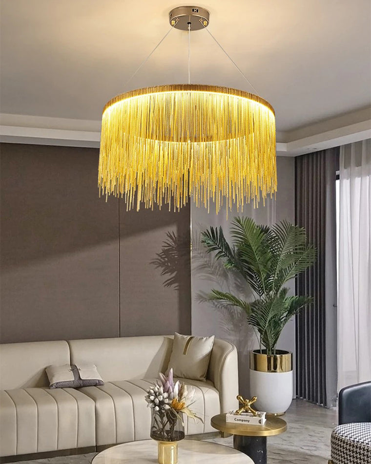 Gold waterfall chandelier above a cream sofa, pouring warm light through cascading chains and giving the living room an instantly finished, cinematic presence.